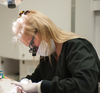 Dr. Snelson is pictured conducting a dental exam on a patient
